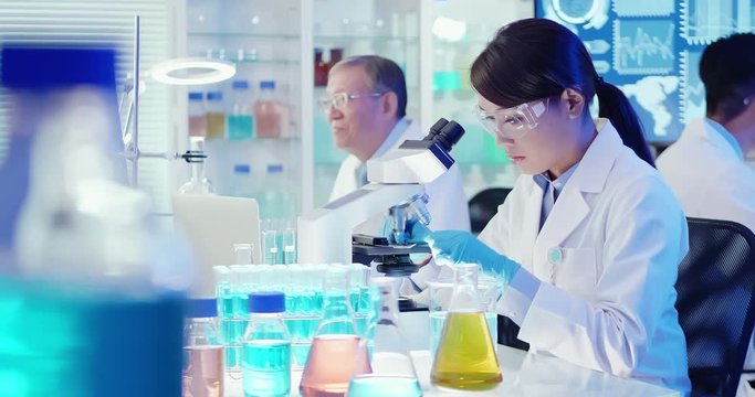 Asian scientist use microscope