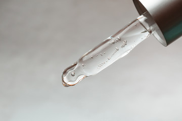 Pipette with drop of hyaluronic acid or serum, macro.