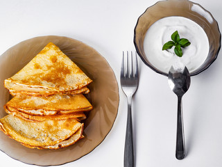 pancakes with sour cream on a plate