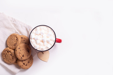 Red mug with cocoa and marshmallows and homemade cookies with chocolate, wooden heart - Christmas tree toy on a light background with copy space