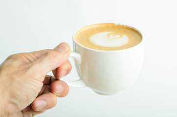 Hand holding a сoffee cup with decorated foam on top