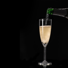 Nalewanie szampana do kieliszka czarne tło © piotrszczepanek