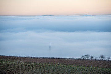 kirchturmspitze ragt aus dem nebel