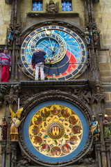 Fototapeta premium Vertical picture of Prague Astronomical Clock (Prague Orloj, Pražský orloj) in the facade of the Old Town Hall (Staroměstská radnice) of Prague, Czech Republic, with men repairing it