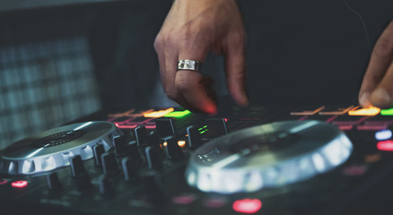 DJ Hands creating and regulating music on dj console mixer in concert nightclub stage