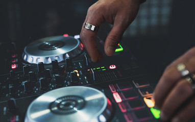 Fototapeta na wymiar DJ Hands creating and regulating music on dj console mixer in concert nightclub stage