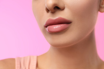 Obraz na płótnie Canvas Woman with glossy lipstick on pink background, closeup