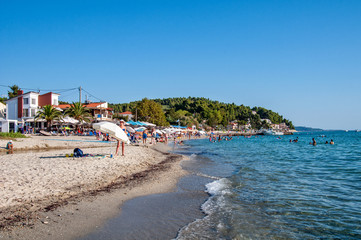 Fototapeta na wymiar Halkidiki, Greece - August 30,2019: Siviri golden Beach and beach tourists. The place of Siviri in Halkidiki, Greece. Blue sea on Aegean sea.