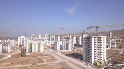 Residential construction site. Tower cranes build large residential buildings. Aerial view of new city construction site.