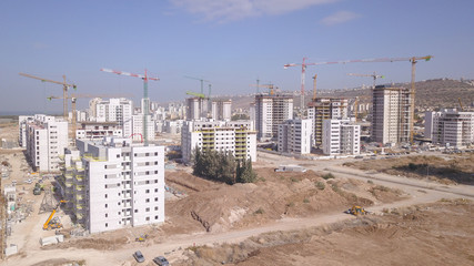 Residential construction site. Tower cranes build large residential buildings. Aerial view of new city construction site.