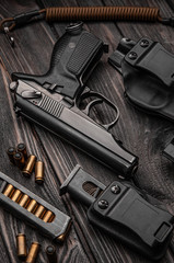 A modern black pistol and ammunition on dark metal background. Weapons for police, army, special forces.