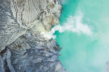 View from above, stunning aerial view of the Ijen volcano with the turquoise-coloured acidic crater lake. The Ijen volcano complex is a group of composite volcanoes located in East Java, Indonesia.