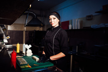 woman chef prepares fresh sushi in the kitchen of the restaurant