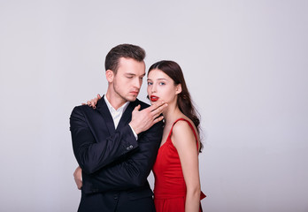 Brutal man in a suit with a sexy brunette together on a white background.