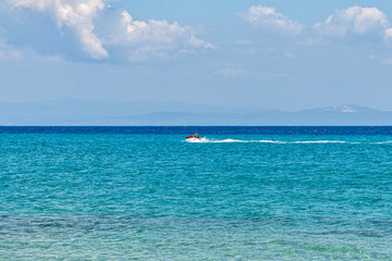 Halkidiki, Greece - September 01,2019: Possidi Beach on Halkidiki, Greece. Personal watercraft or Water motorcycle. Blue sea and a jet ski floating on Aegean sea.