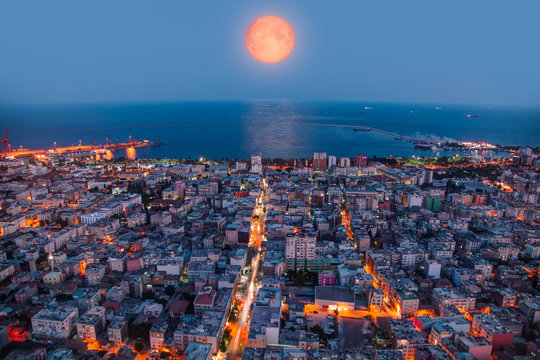 Mersin City and port at night with full orange moon. "Elements of this image furnished by NASA