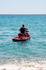 Fototapeta na wymiar Halkidiki, Greece - September 01,2019: Possidi Beach on Halkidiki, Greece. Personal watercraft or Water motorcycle. Blue sea and a jet ski floating on Aegean sea.