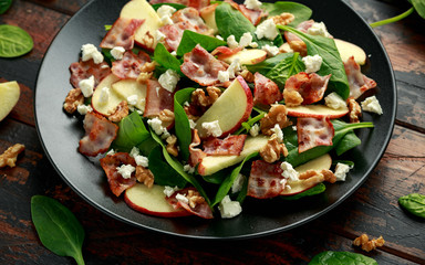 Bacon, Apple Salad with spinach, walnuts and feta cheese. on wooden table. healthy food.