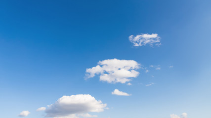 Small clouds on a blue gradient sky background. Clouds go up, 16:9