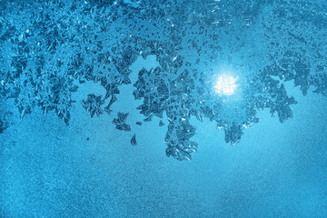 Ice pattern and sunlight on morning winter glass