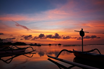 sunset over traditional fishing boats on Bali