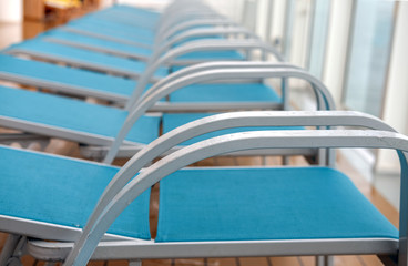 Schlechtes Reisewetter: Leere und nasse Liegestühle nach einem Regenschauer auf einem Kreuzfahrtschiff