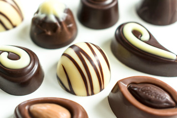  A lot of different chocolates on a white background. Close-up.