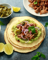 Mexican Corn tortilla with shredded Pork, avocado, red onion and jalapeno