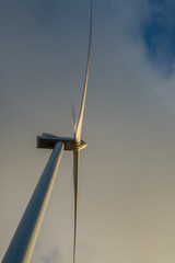 Windmill photographed from below with a cloudy sky as background