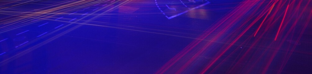 Car tail light trails and headlight traces and road turn sign in darkness overlook with blue neon street lamp