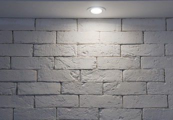 White brick wall lit by a lamp