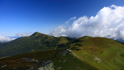 Fototapeta na wymiar Beautiful green mountain ridge with clouds.