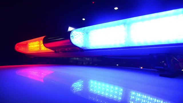 Police emergency lights flash at night. Flashlights. Crime scene. Car accident and traffic jam. Flashing blue and red lights and signals on patrol car. Emergency car in action. Police raid and control