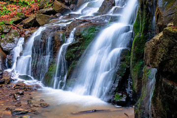 Fototapeta premium waterfall skakalo in the forests of transcarpathia. rapid water stream runs down the huge boulders. clear water of carpathian nature in springtime. long exposure