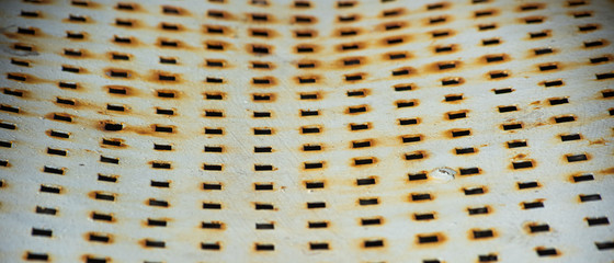 Horizontal bent metal plate with perforation coated with corrosion