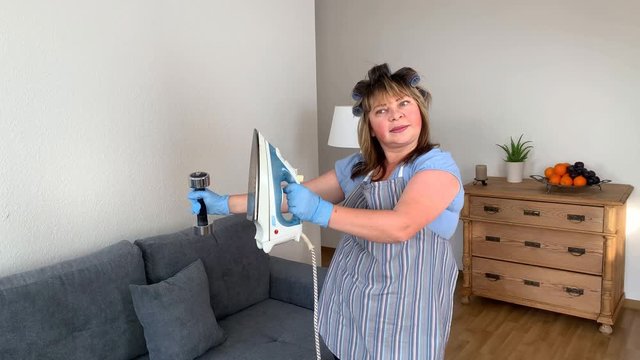 fat middle-aged woman, a housewife in an apron performs physical exercises at home with a dumbbell and iron, the concept of sports, weight loss, physical activity, healthy lifestyle