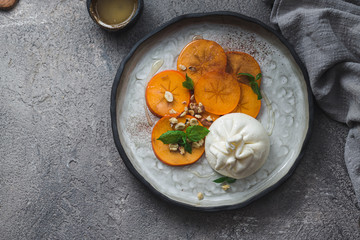 Buratta cheese with persimmon and nuts appetizer, copy space
