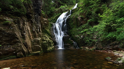 Naklejka na ściany i meble Waterfall in green forest