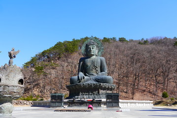 Fototapeta premium Tourists praying at The Great Unification Buddha (Tongil Daebul) at Shinheungsa temple, Seoraksan National Park, Sokcho, South Korea
