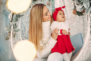 Mother in a white sweater. Family in a studio. Little girl in a cute dress