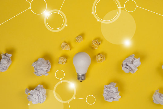 New Idea Concept With Crumpled Office Paper And White Light Bulb On Yellow Background. Creative Solution During Brainstorming Session Concept. Flat Lay, Top View, Copy Space