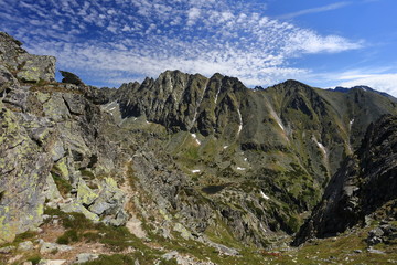 Rocky mountain ridge with little clouds.