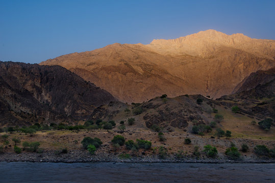 Central Asia, Tajikistan. View from the right coast of the border river Panj on the Pamir mountains in Afghanistan. © Александр Катаржин