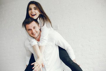 Cute couple on a kitchen. Pretty brunette in a white shirt.