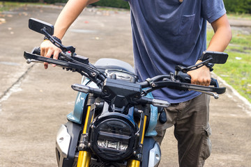 A Biker drives a broken motorcycle along a country road