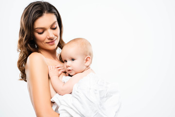 portrait of smiling naked mother hugging baby boy, isolated on white