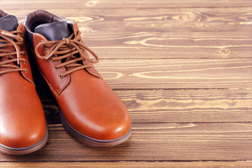 Stylish men's shoes on a wooden background with place for text.