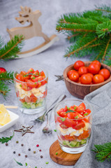Portion salad with smoked salmon, avocado, egg, cherry tomatoes with cream cheese dressing in a glass.  Holiday salad for Christmas and New Year.