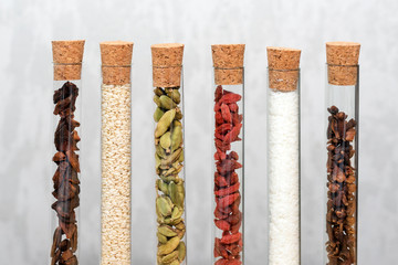 Various spices in glass flasks. Homemade spices ingredients for cooking, cardamom, coconut, cloves, star anise, goji berries.