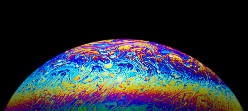 Close up picture of soap bubble psychedelic color half circle shape on black background